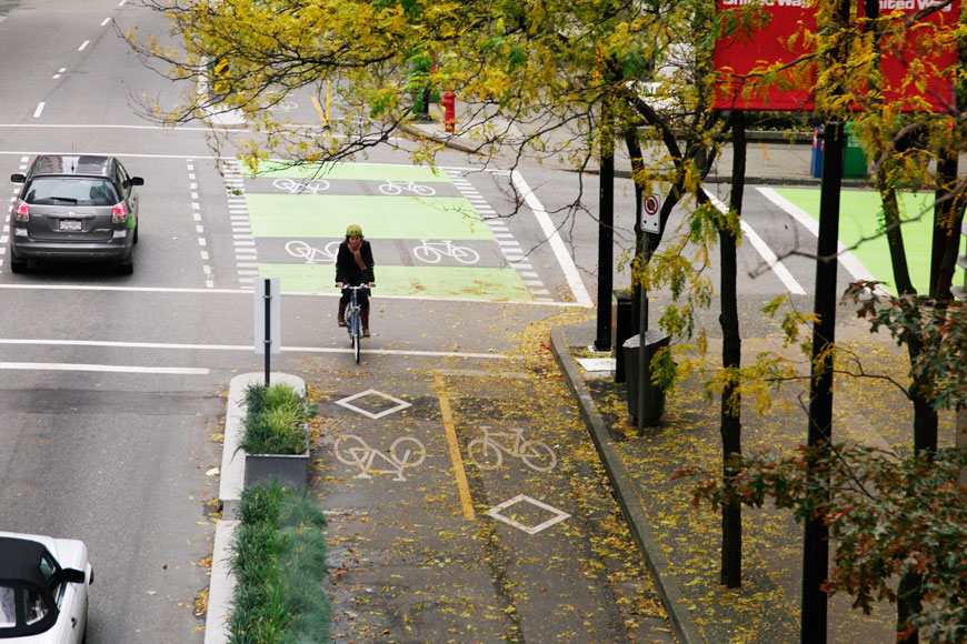 一名骑自行车的人骑在不列颠哥伦比亚省温哥华的受保护的自行车道中。