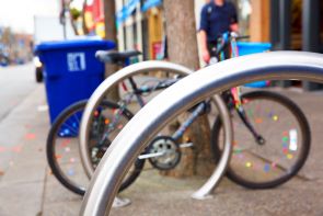 一系列弯曲的不锈钢室外自行车架固定了一辆颜色鲜艳的自行车