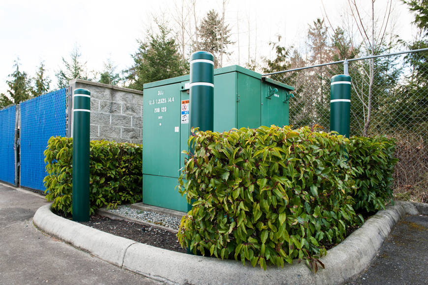 高大的绿色安全杆盖保护一个大的绿色电盒