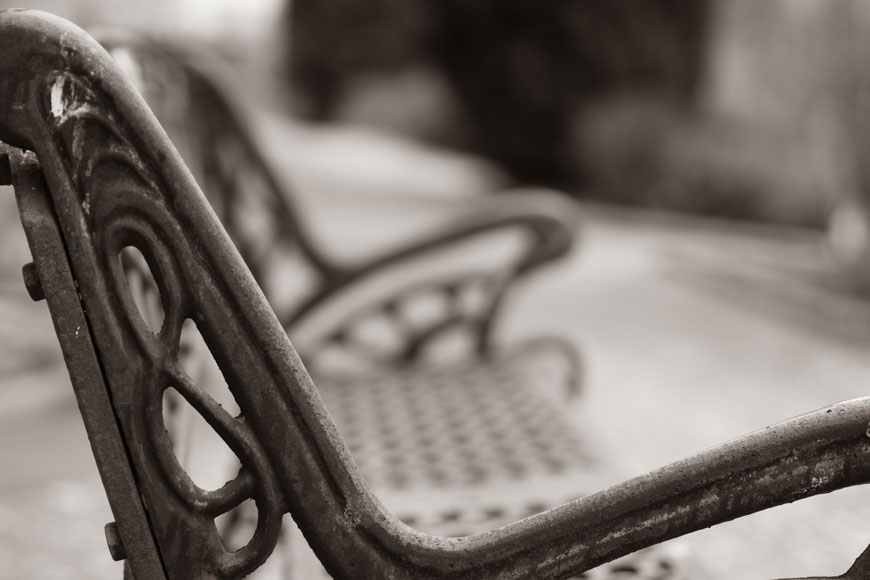 一张饱经风霜的铸铁长凳华丽一面的特写照片