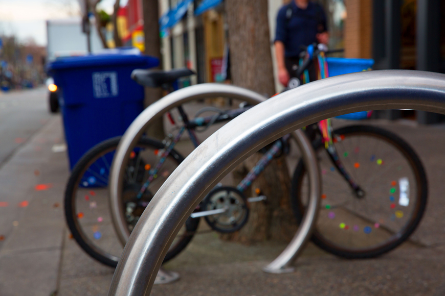 一辆装饰鲜艳的自行车附在不锈钢环形自行车停车场上