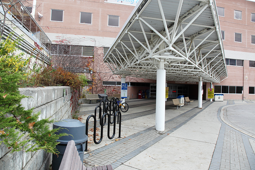 医院的接待湾具有自行车架，垃圾和回收罐和长椅