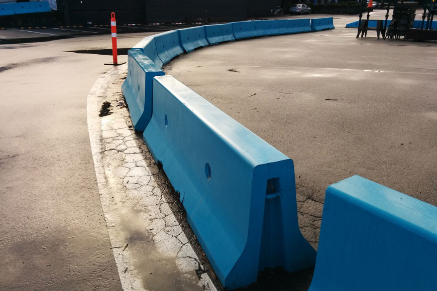 蓝色混凝土屏障的弯曲线保护铺砌区域免受车辆通行