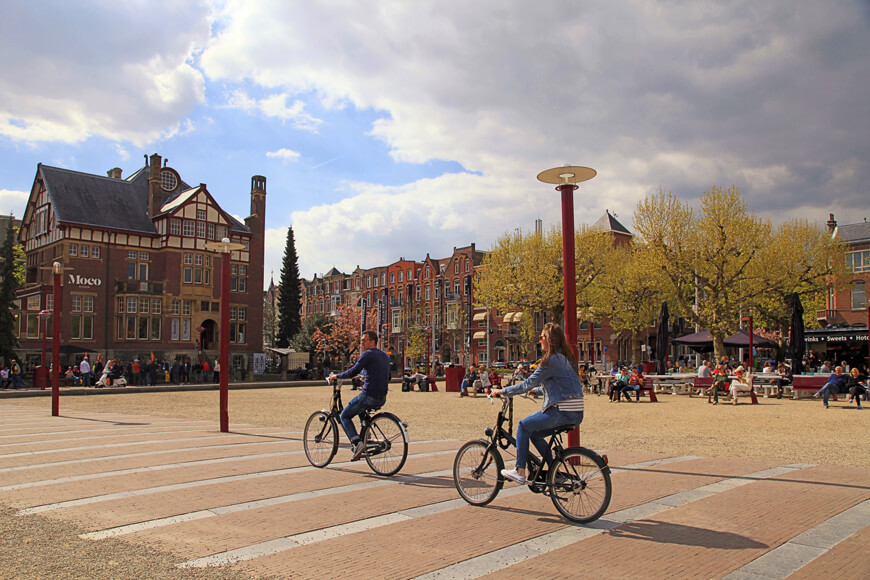 骑自行车的男人和女人在历史中心揭示了阿姆斯特丹的自行车文化