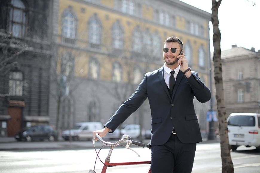 一位微笑的男士在工作之余靠在自行车上