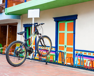五颜六色的装饰自行车架与附近的一栋彩色建筑相匹配