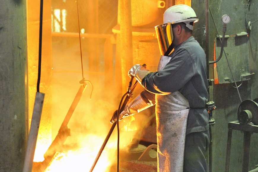 一个工人测试金属温度穿着铸造安全服