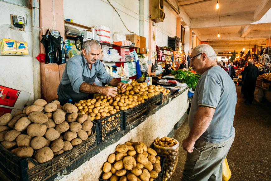在市场上，一名土豆推销员向一名年长的男性顾客推销新土豆