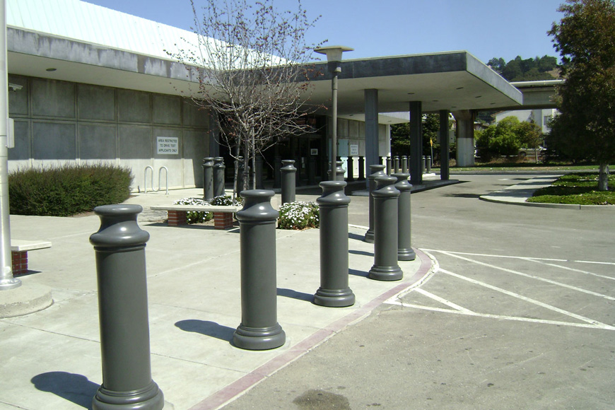 灰色的柱状柱子覆盖着弯曲的盖子和底座，形成了低矮建筑的周边