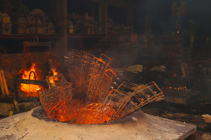 从肮脏的感应金属炉中凸出的薄金属屑被锈和热染成红色