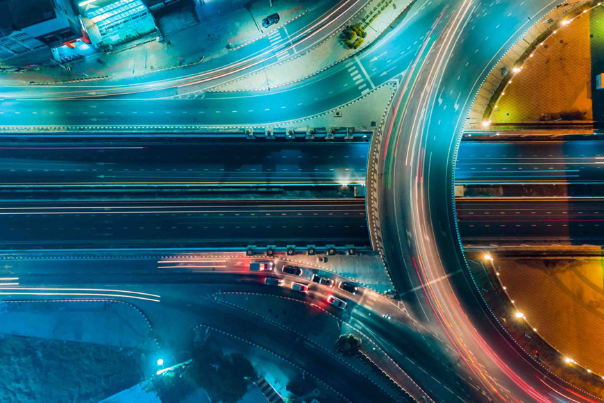 高速公路的鸟瞰图在夜间闪烁着移动的汽车的条纹灯