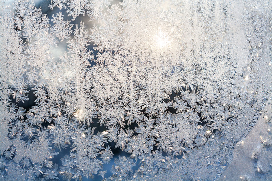 阳光透过一个窗户覆盖着霜的绽放