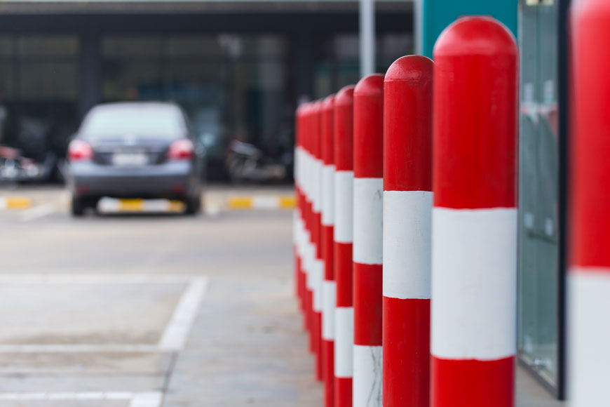 涂有鲜艳的红色和白色条纹绑带柱在停车场创建障碍物