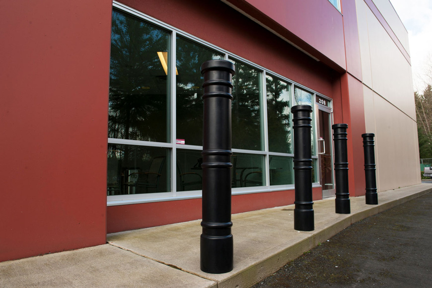 四根细长的黑色护柱和三套装饰环保护办公大楼