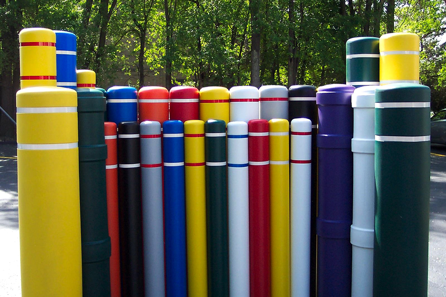 塑料柱布覆盖不同的宽度，高度和颜色簇在树木面前。