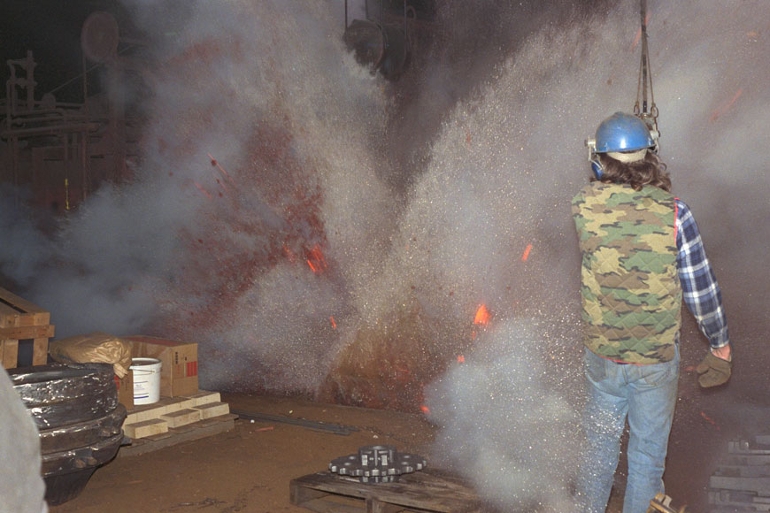 在一次淬火爆炸中，一名铸造工人被一股炽热的流光包围着