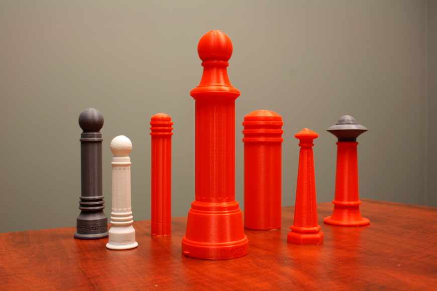 一系列小塑料模型系珠橙色，白色或灰色站在桌子上