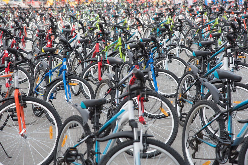 许多自行车并排停放在城市广场上
