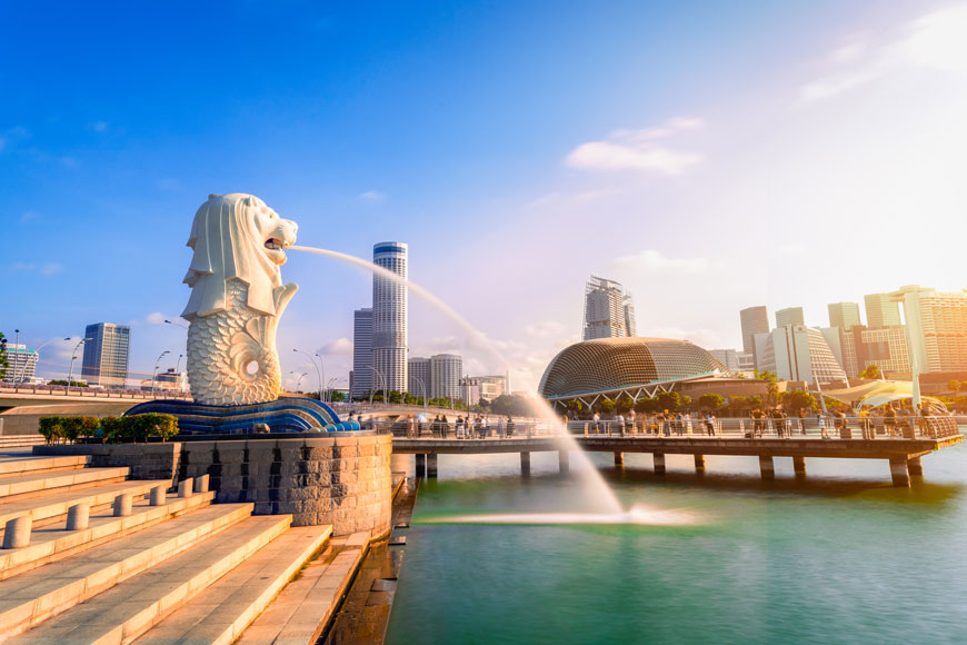 新加坡的鱼尾狮雕像在日出的天际线前喷水