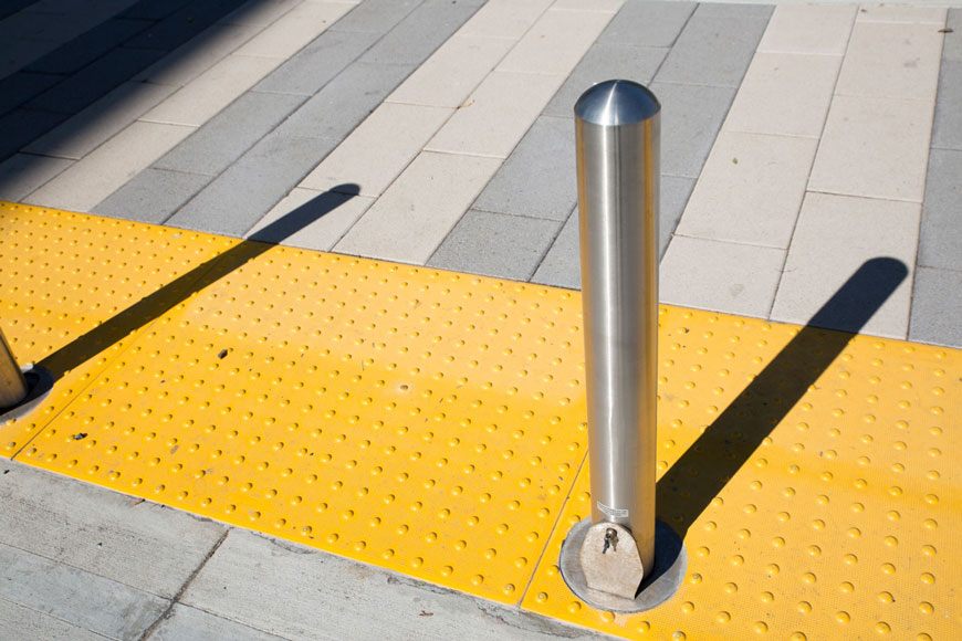 一个可拆卸的不锈钢系柱嵌入旁边的黄色可检测警告板