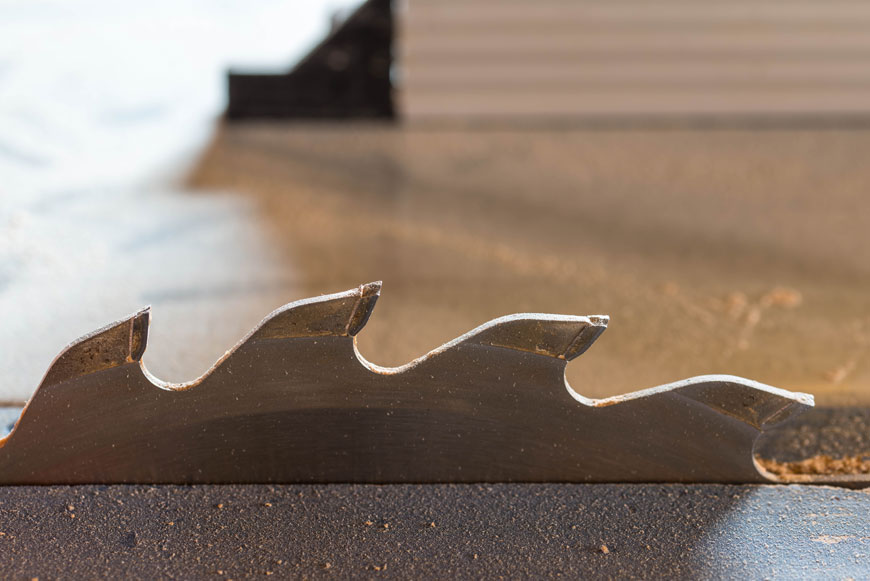 一个锯齿形锯齿台锯的特写显示牙齿上有两种不同的金属。