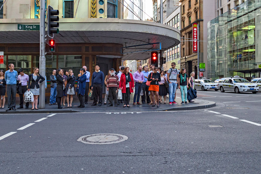 一群人在城市街景中的十字路口等待灯光变化