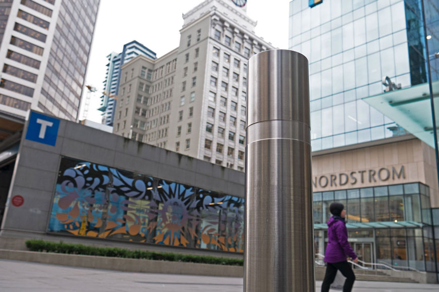前景中的一个不锈钢系螺母展示了一个吸引人的城市场景和艺术车站绘画
